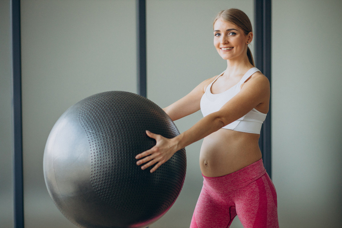 pilates pregnant woman exercising with fit ball class