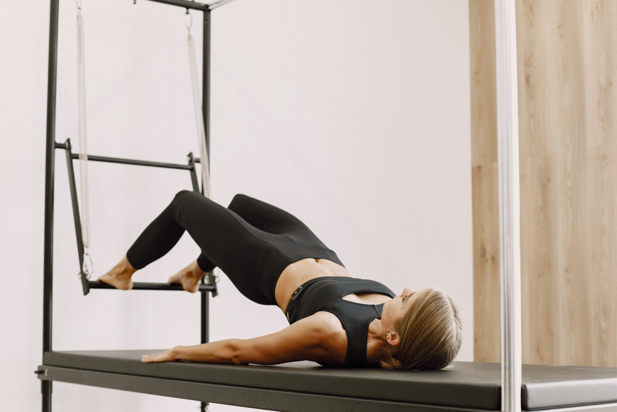pilates fit woman training stretching with equipment