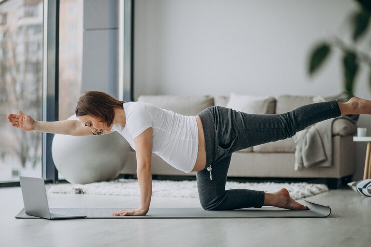 pilates pregnant woman exercising balance breathing