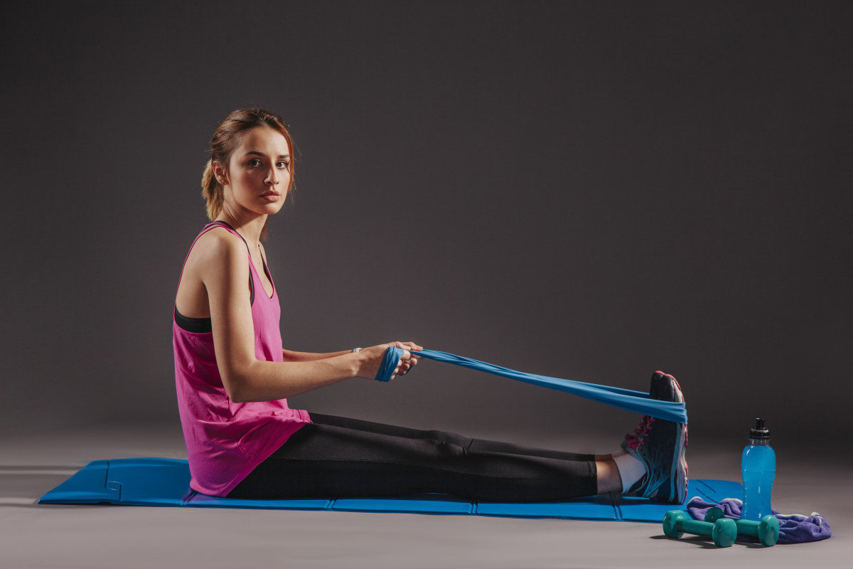 pilates woman elastic band mat exercising